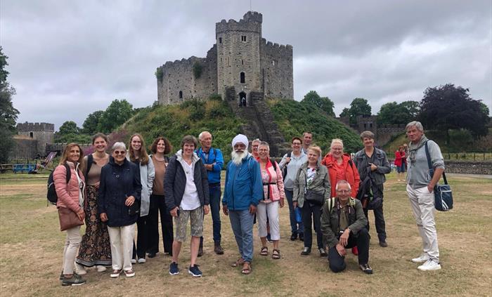A group of adults standing in front of the Norman keep at Cardiff Castle